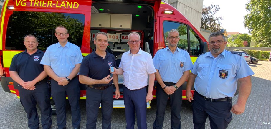 Bürgermeister Holstein überreicht dem Leiter der Führungsstaffel, Marc Bente, den Schlüssel zum neuen Einsatzleitwagen.