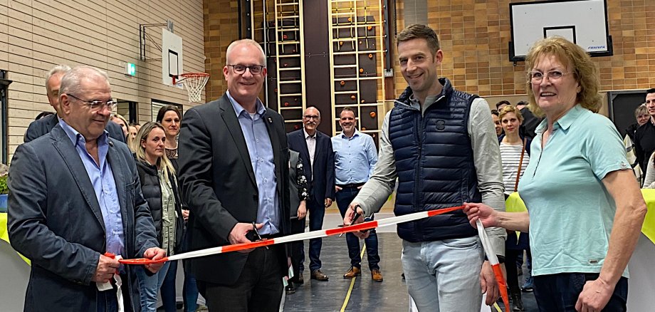 Durchschneiden eines Bandes zur Einweihung Turnhalle Kordel