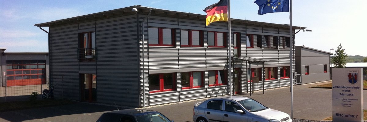 Gebäude des Technischen Dienstleistungszentrums Graues Flachdachgebäude des Technischen Dienstleistungszentrums mit Flaggen vor der Eingangstür