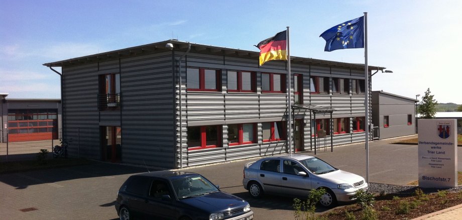 Gebäude des Technischen Dienstleistungszentrums Graues Flachdachgebäude des Technischen Dienstleistungszentrums mit Flaggen vor der Eingangstür