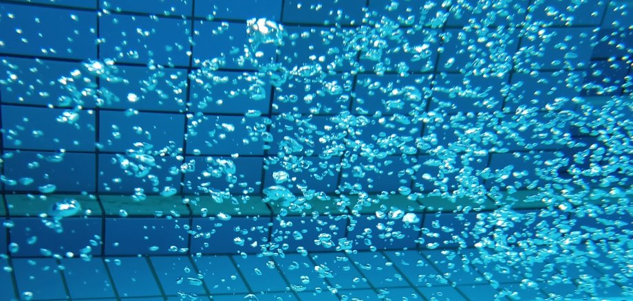 Blaues Wasserbecken mit sprudelnden Wasserperlen