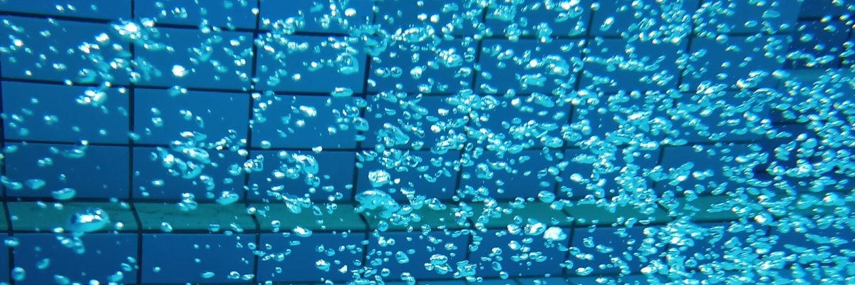 Blaues Wasserbecken mit sprudelnden Wasserperlen