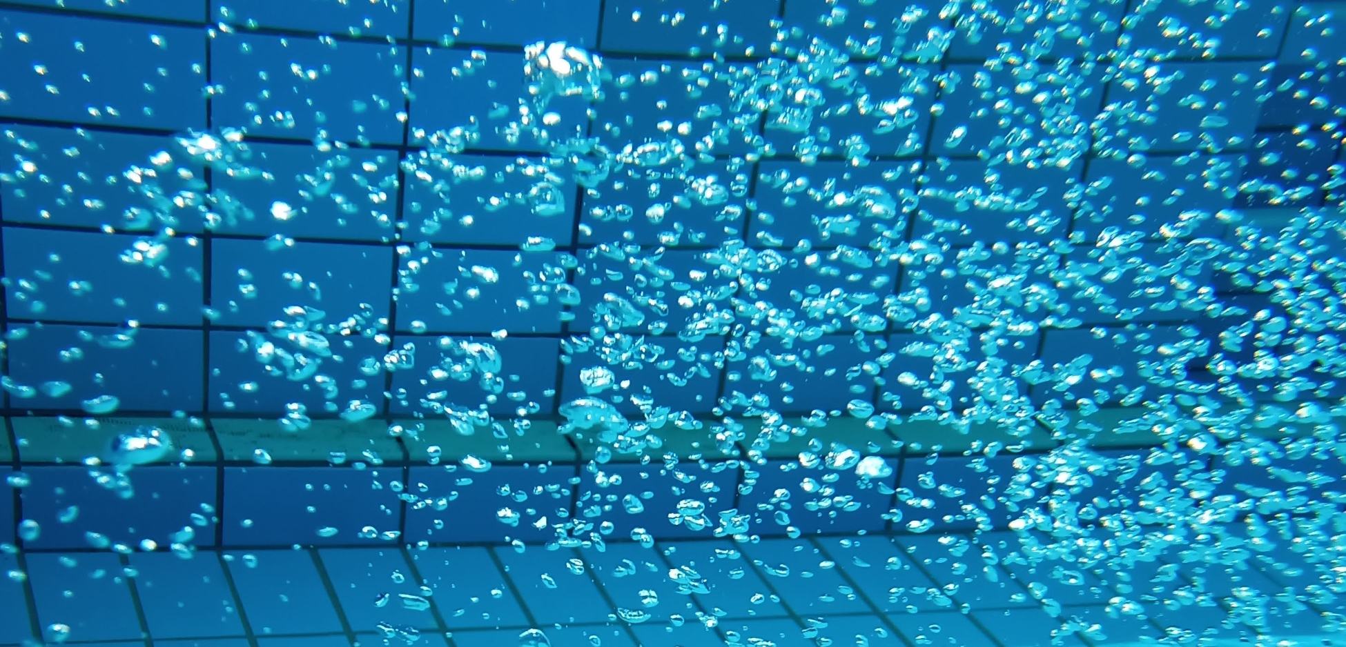 Sprudelndes Wasser Blaues Wasserbecken mit sprudelnden Wasserperlen