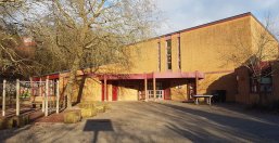 GS Igel Gebäude der Grundschule Igel, gelbe Fassade und überdachter Eingang.