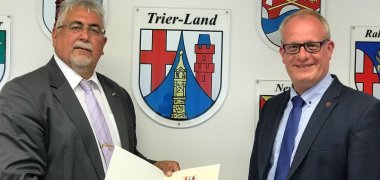 Bürgermeister Holstein (rechts) übergibt die Stefan Hoffmann (links) die Ernennungsurkunde zum Behindertenbeauftragten der VG Trier-Land 